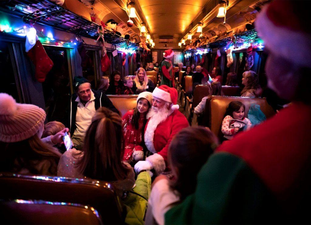 santa sitting with guests on the polar express